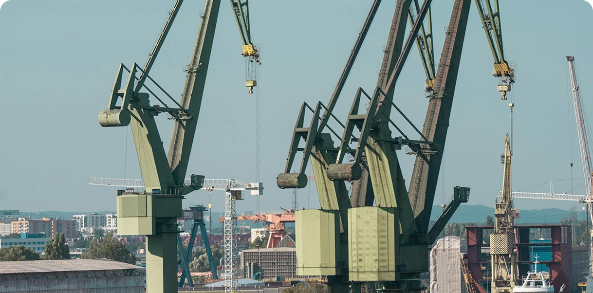 A large construction crane towers over a bustling cityscape, highlighting urban development and activity.